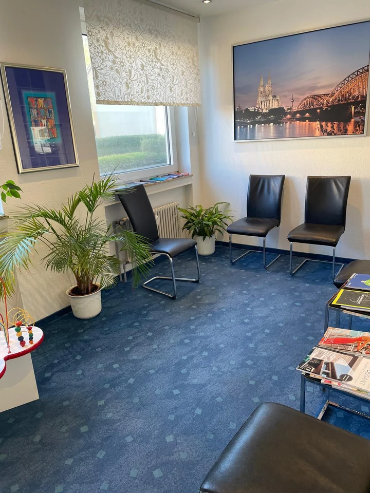 Wartezimmer der Praxis mit Freischwingerstühlen, Pflanzen und Wandbildern